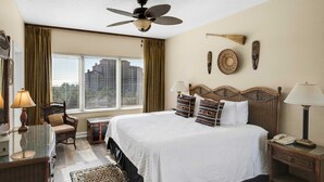 A hotel room with a large bed, a ceiling fan, a view of the city, and a window with curtains. - Luxury condo w/private balcony & resort access (Miramar Beach)