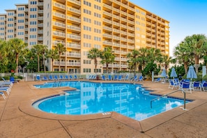 A hotel with a swimming pool, multiple balconies, and palm trees. - Exclusive 2BR: ocean views, pool, hot tub (Miramar Beach)