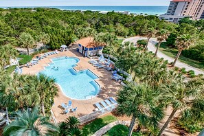A resort with a large swimming pool, lounge chairs, and palm trees. - Exclusive Studio: Balcony, Pool, Beach Access (Miramar Beach)