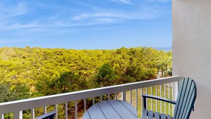 A balcony with a view of a forested landscape. - Exclusive Studio: Balcony, Pool, Beach Access (Miramar Beach)