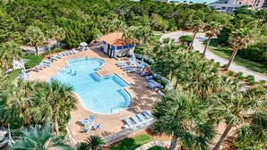 A resort with a large swimming pool, lounge chairs, and palm trees. - Steps to beach, ocean views, pool access (Miramar Beach)