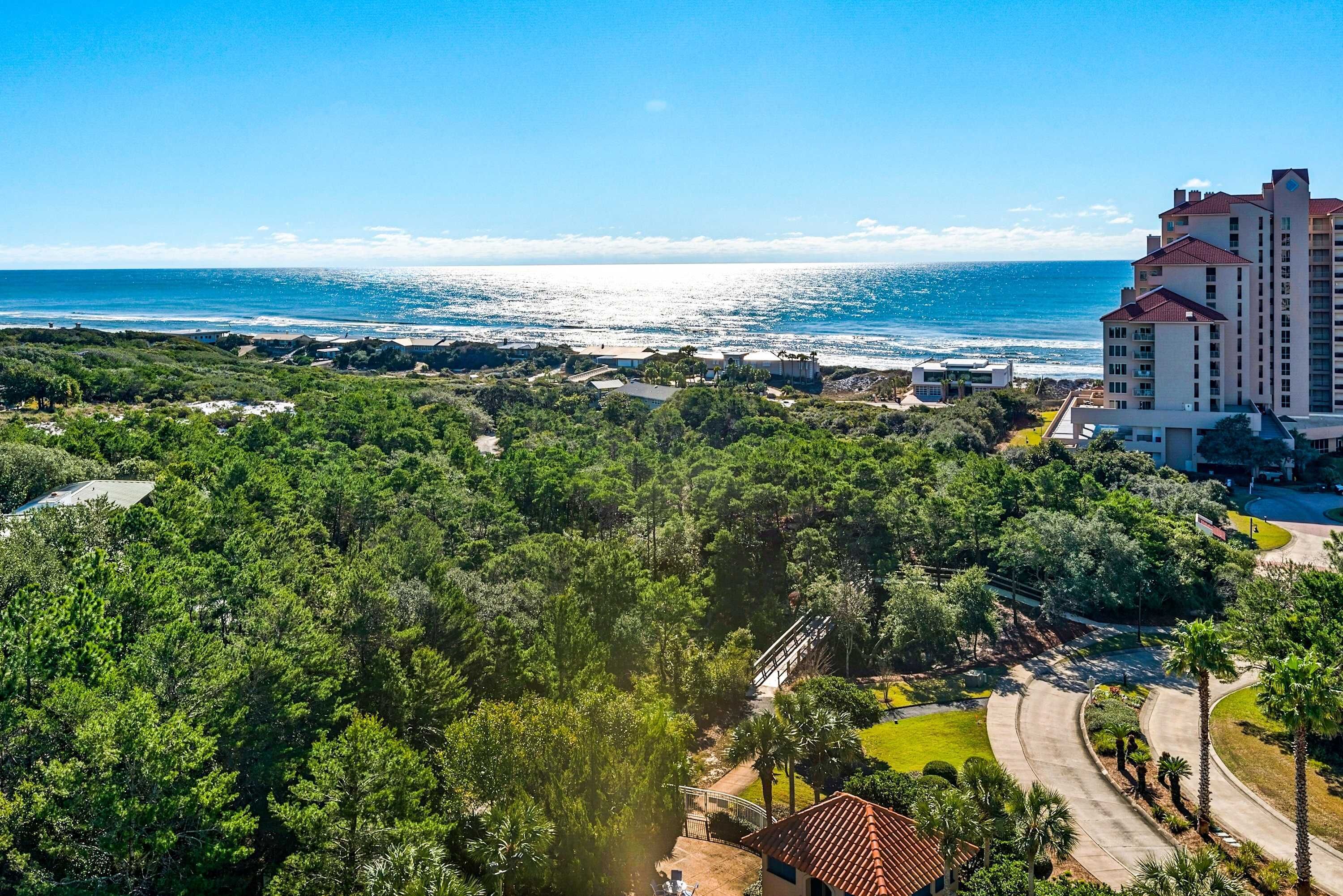 Ein Küstenhotel mit Meerblick, umgeben von üppiger Vegetation und einer gewundenen Straße.