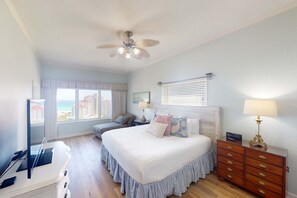 A bedroom with a bed, bedside tables, a dresser, a ceiling fan, and a window with a view. - Private beach condo with Gulf views (Miramar Beach)