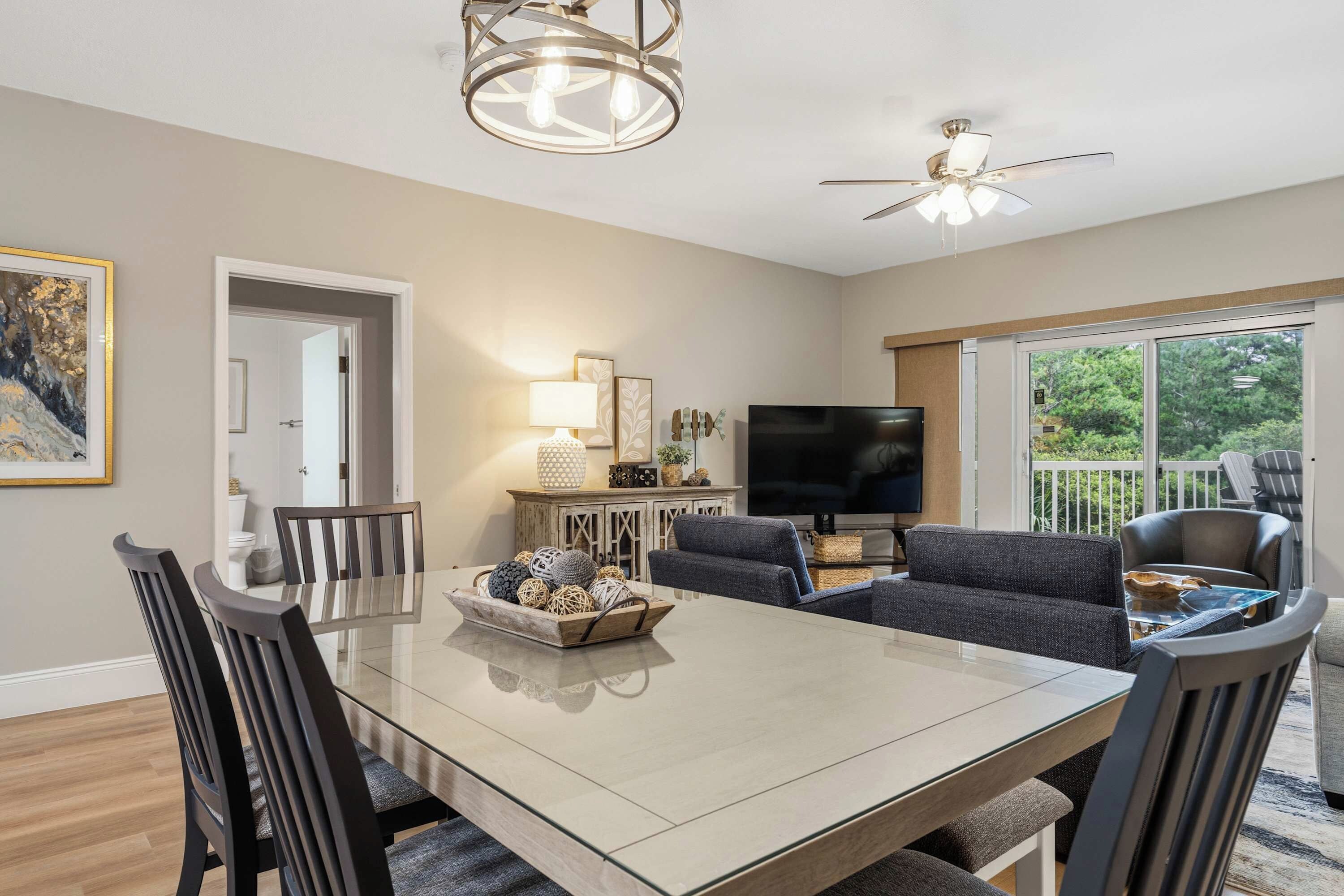 A modern living room with a dining table, sofas, and a TV.