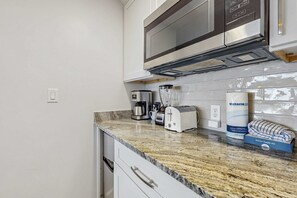 A kitchen with a microwave, coffee maker, toaster, and a Victoria sponge box. - 1BR retreat: hot tub, steps to beach access (Miramar Beach)