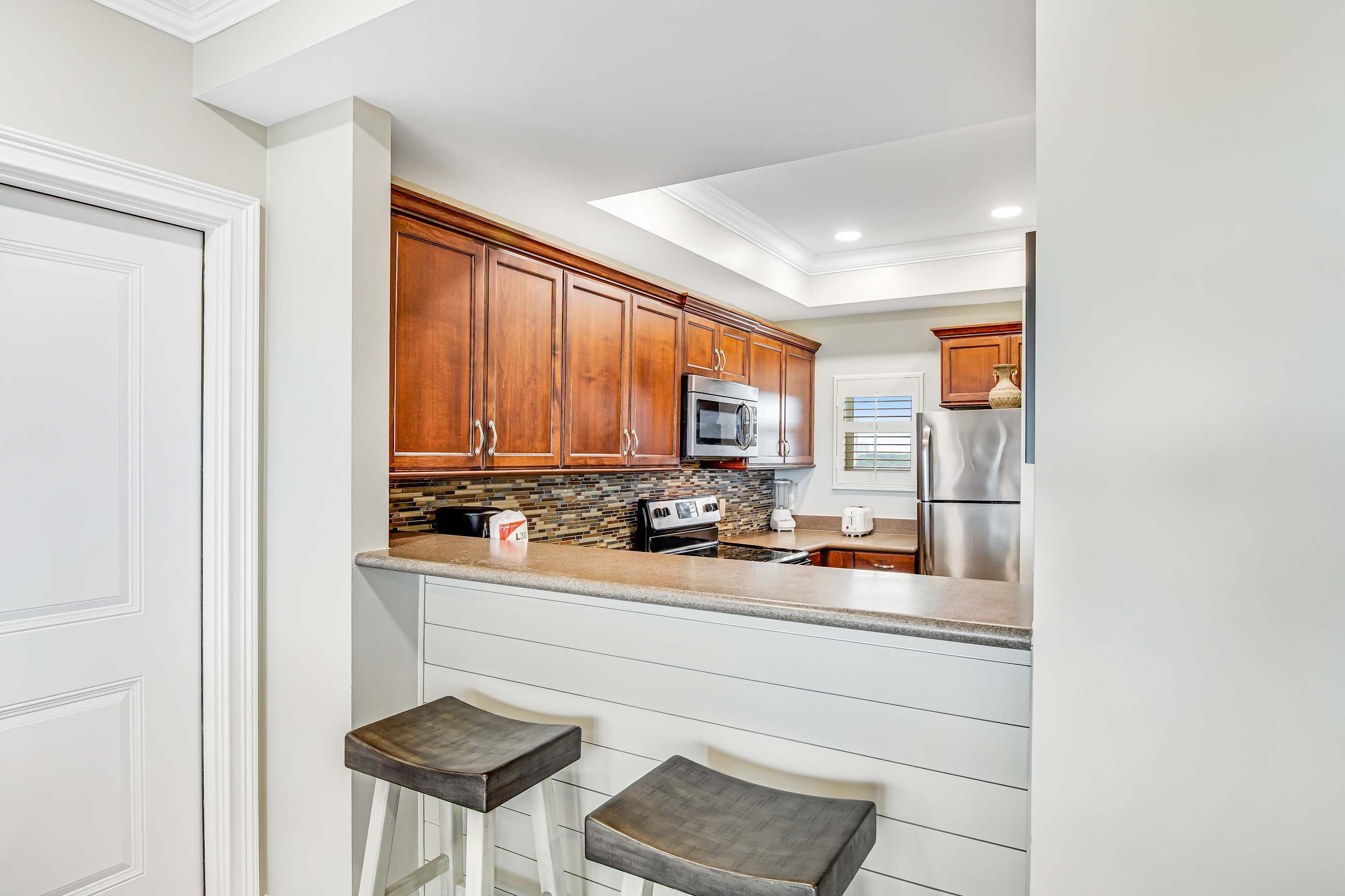 A kitchen with wooden cabinets, a microwave, a stove, and a refrigerator.