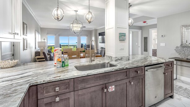 A modern kitchen with a large island, dark cabinetry, and pendant lighting. - Shoreline views, private balcony retreat (Miramar Beach)