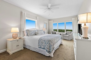 A bedroom with a bed, nightstand, chair, and a view of the outdoors. - Steps to Beach | Scenic Views | Resort Amenities (Miramar Beach)