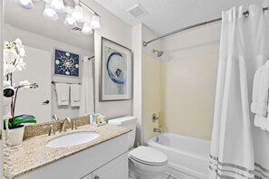 A bathroom with a sink, toilet, and bathtub. There are towels and a potted plant. - Steps to Beach | Scenic Views | Resort Amenities (Miramar Beach)