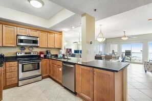 A modern kitchen with wooden cabinets, stainless steel appliances, and a large island. - Gulf Views & Resort Access, Beach Steps Away (Miramar Beach)