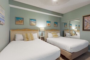 A hotel room with two beds, a small table with a lamp, and wall art. - Resort Condo Near Beach w/ Pools & Hot Tub (Miramar Beach)