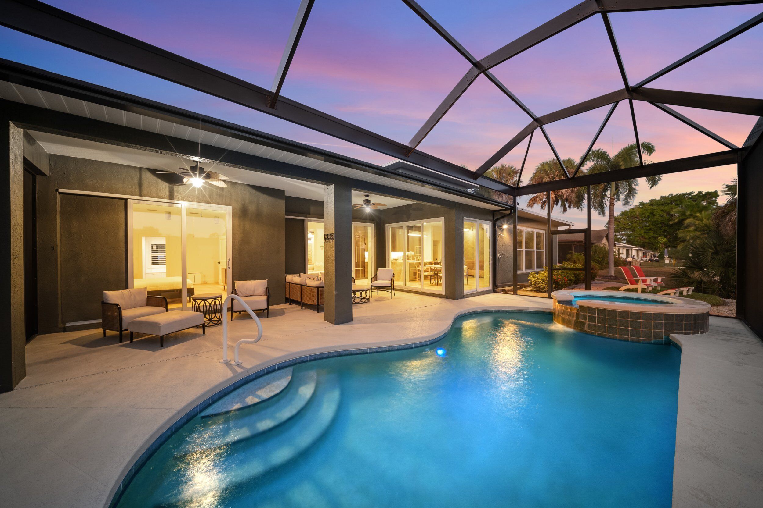 Un área de piscina interior moderna con diseño curvo, asientos y vistas al cielo.