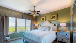 A bedroom with a bed, nightstands, a ceiling fan, and large windows. - Exclusive 3BR condo with Gulf views (Miramar Beach)