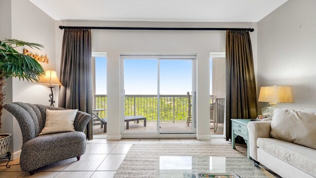 A living room with a sofa, a chair, a coffee table, and a balcony with a view. - Exclusive Gulf View 2BR with Pool Access (Miramar Beach)