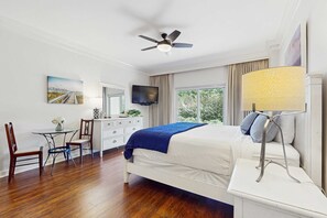 A bedroom with a bed, a desk, a chair, a television, and a window with curtains. - Steps to beach, cozy retreat with pool access (Miramar Beach)