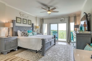 A bedroom with a bed, bedside tables, a ceiling fan, a large window, and a view of the outdoors. - Scenic balcony views & resort pool access (Miramar Beach)