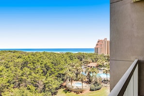 A view of a hotel with a pool, surrounded by dense greenery and a clear blue sky. - Exclusive studio: Gulf views, resort perks (Miramar Beach)