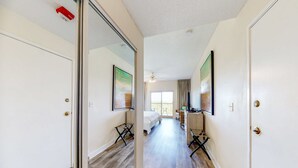 Ein Hotelzimmer mit Bett, Schreibtisch, Stuhl, Fenster und Tür.