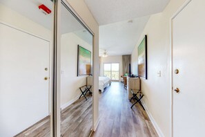 A hotel room with a bed, a desk, a chair, a window, and a door. - Studio for 2: pool, beach access & balcony (Miramar Beach)