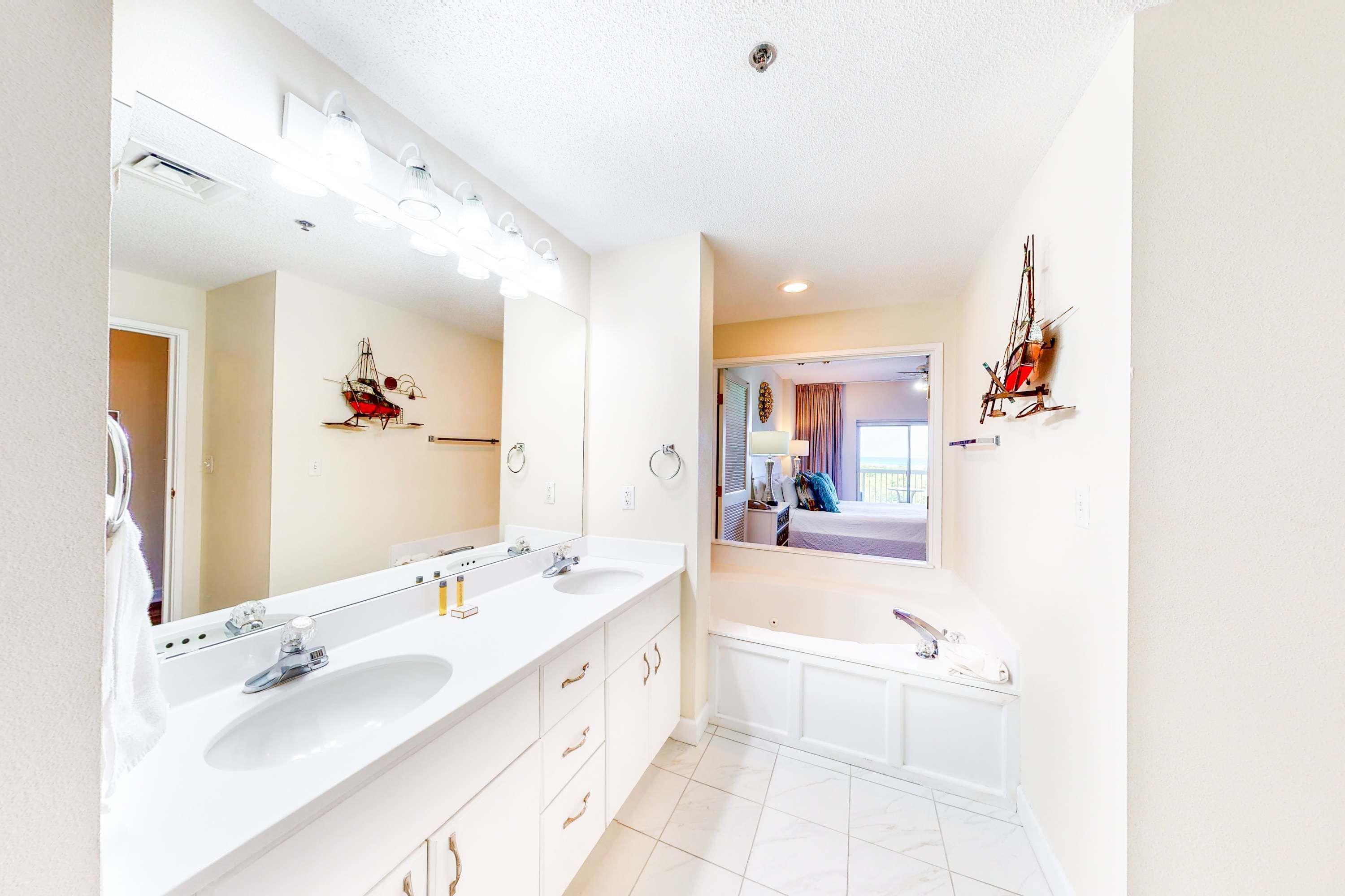 A bathroom with two sinks, a mirror, and a bathtub.