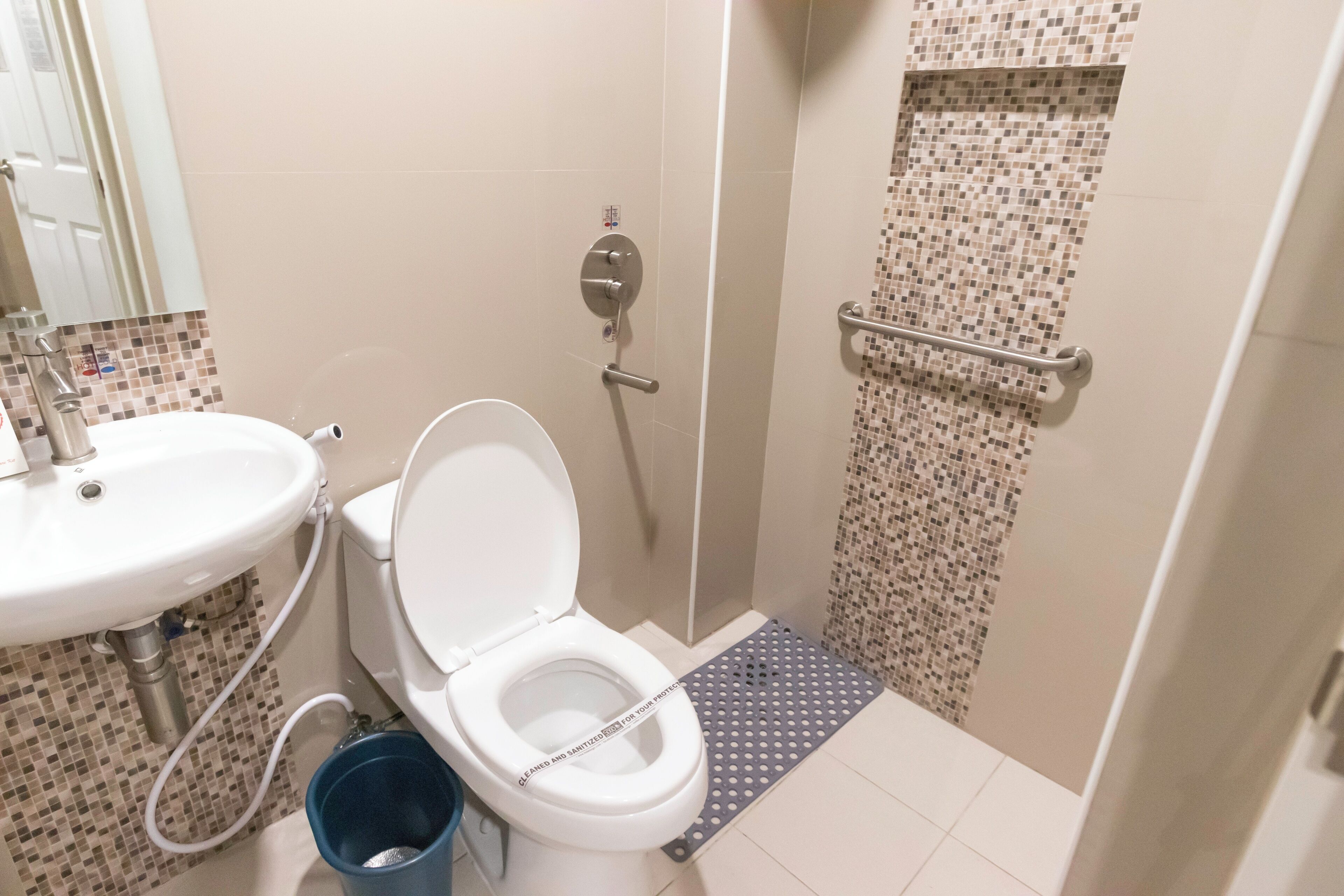A bathroom with a toilet, sink, and shower area.