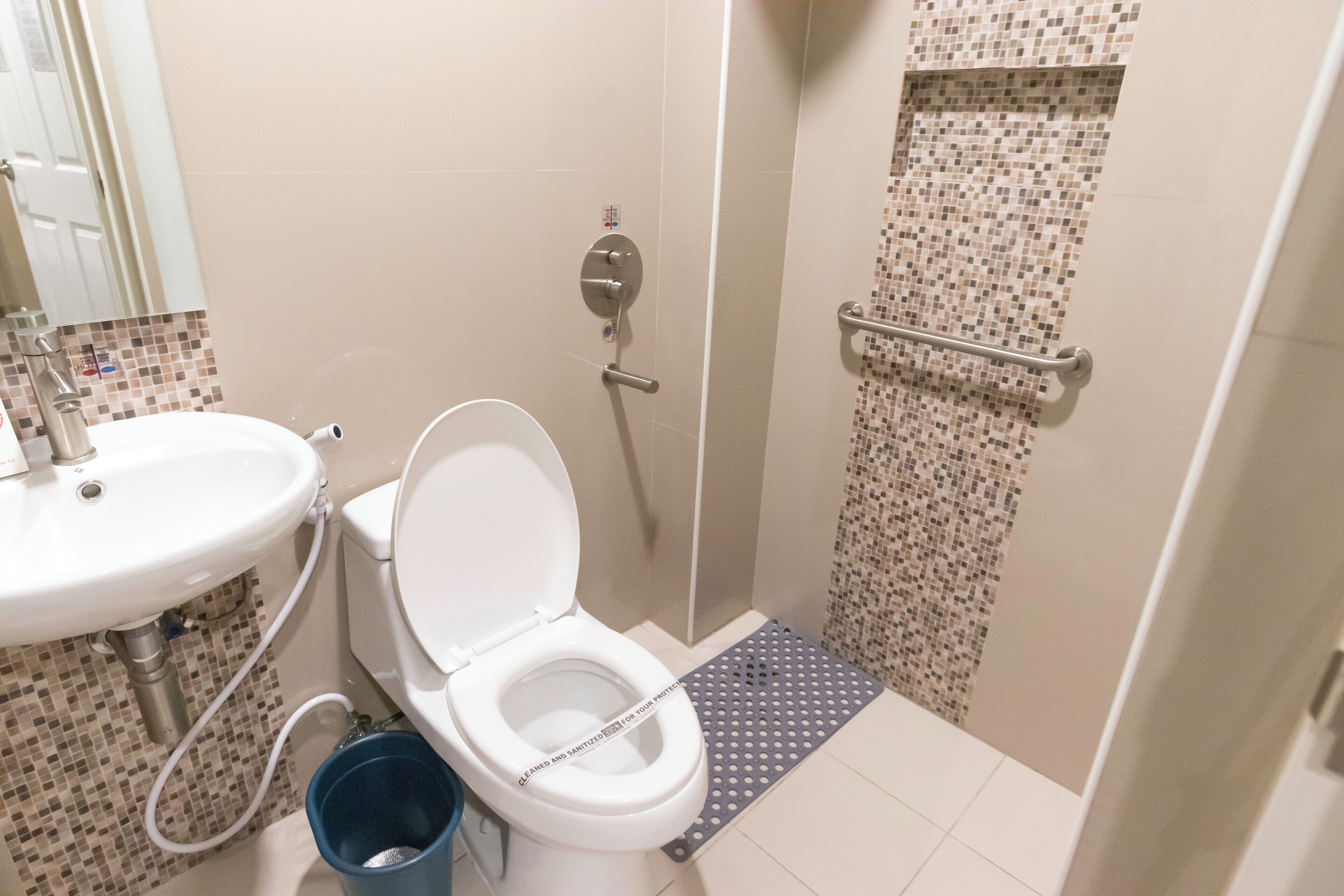 A bathroom with a toilet, sink, and shower.