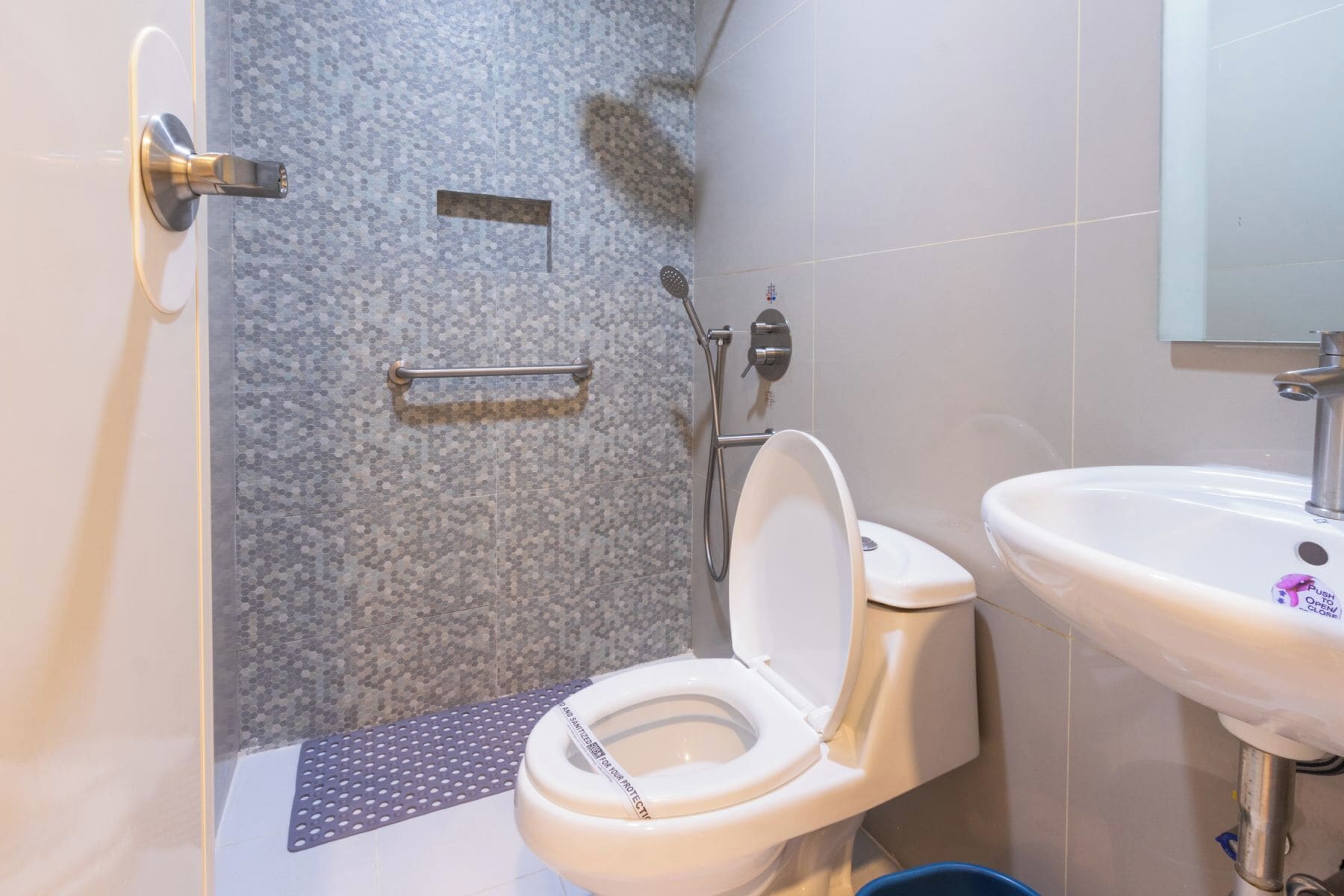 A bathroom with a toilet, a sink, and a shower.