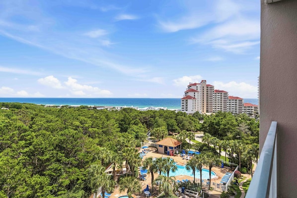 A resort with a pool, palm trees, and a view of the ocean. - Exclusive beachfront studio for 2 (Miramar Beach)