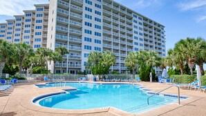 A hotel with a swimming pool, palm trees, and a large building with balconies. - Exclusive Gulf-view penthouse, sleeps 6 (Miramar Beach)