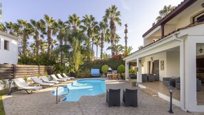 A backyard with a swimming pool, lounge chairs, and a patio area with outdoor furniture. - Villa Relax, just steps from Latchi beach with a private pool and terraces. (Latchi Beach)