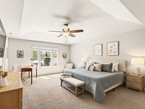 A bedroom with a bed, a desk, a chair, a bench, a bedside table, a lamp, and a ceiling fan. - Family Friendly 4-bedroom Home with Hot Tub Near BSU, Downtown and Airport (Boise)