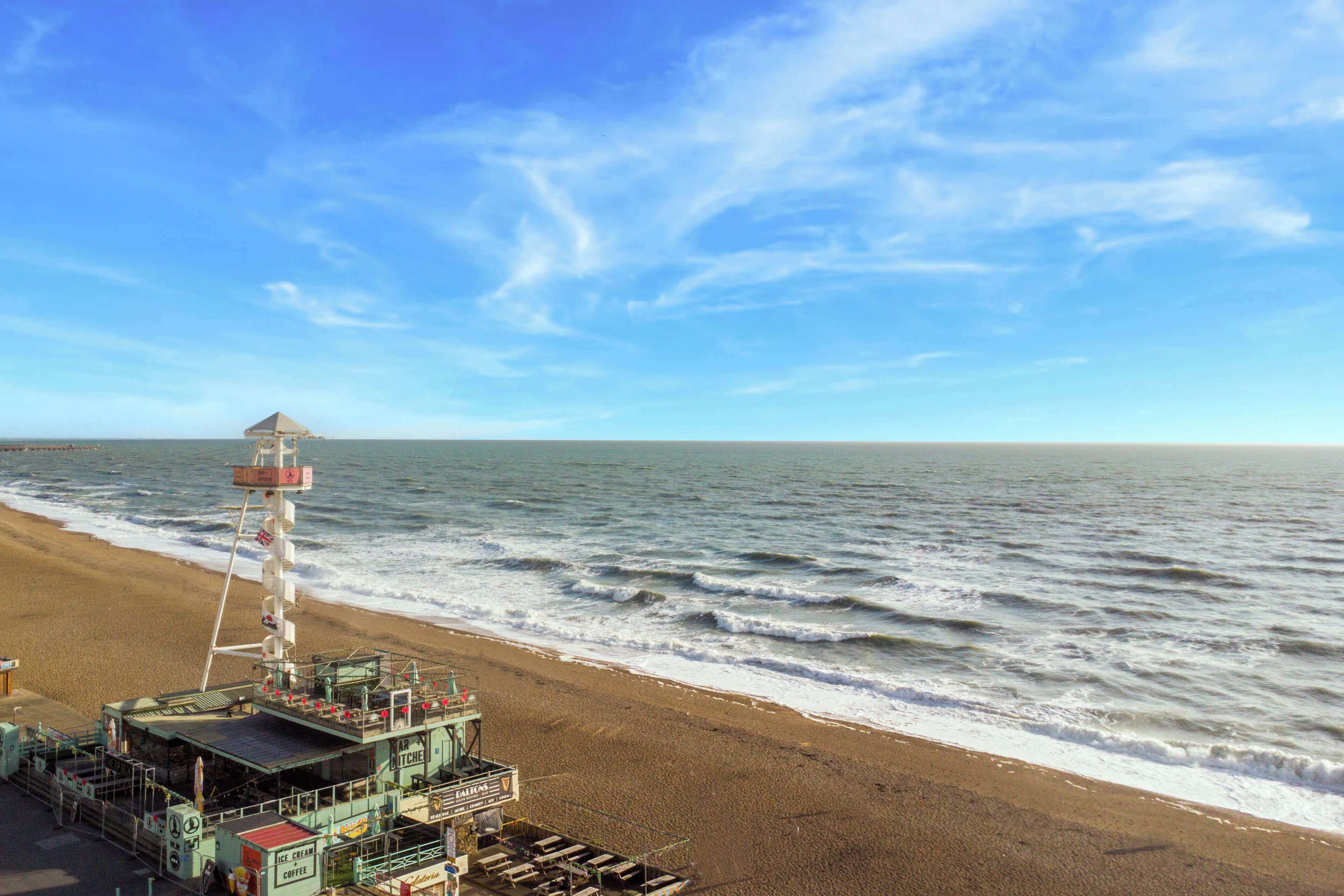 A beachside pier with a lifeguard tower, a bar, and a restaurant.