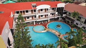 Un hôtel doté d’une piscine sur le toit, de plusieurs piscines et d’un jardin aménagé.