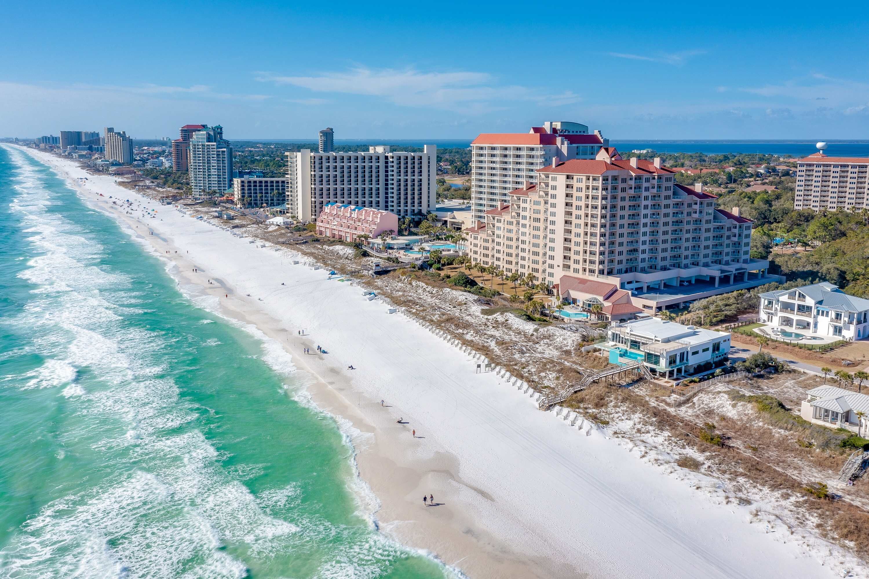 Ein Küstenhotel mit direktem Strandzugang, mehreren Hochhäusern und freiem Blick auf den Ozean.