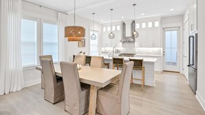 Una cocina moderna con armarios blancos, una isla central e iluminación colgante.