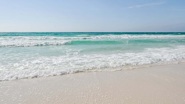 Una playa con agua turquesa cristalina y arena blanca.