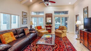 A spacious living room with a leather sofa, two armchairs, a coffee table, and a television. - 3BR villa, steps to beach + Captiva pool (Miramar Beach)