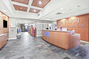 A reception desk with a sign for 'TOP'S L Boutique Racquet Club' and a 'CLUB REGISTRATION DESK' sign. - 3BR villa, steps to beach + Captiva pool (Miramar Beach)