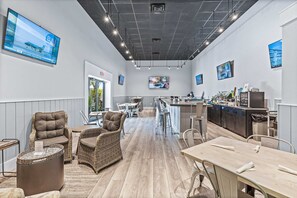 Un moderno vestíbulo de hotel con bar, zona de estar y cocina.