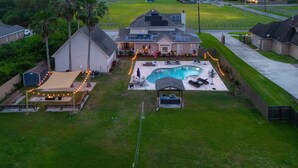 A residential property with a swimming pool, outdoor seating, and solar panels.