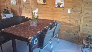 A wooden interior with a dining table, chairs, and wall-mounted clocks. - Renovated house • Air conditi• Garage • BR-116 • Route to the beaches of SC (Guaíba)