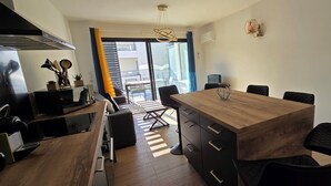 A modern kitchen with a wooden dining table, black chairs, and a view to the outside. - Nice and cozy T2, near beaches, Terra Doru B02 (Propriano)