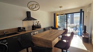 A modern kitchen with a wooden countertop, black appliances, and a large window overlooking a balcony. - Nice and cozy T2, near beaches, Terra Doru B02 (Propriano)