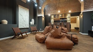 A modern interior with a brick ceiling, wooden flooring, and a seating area with bean bags and chairs. - Posh 3BR Escape – Sauna, Billiard, Spacious 212 m² (Wien)
