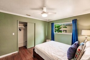 A bedroom with a bed, a ceiling fan, a window with curtains, and a closet. - Bnb Hyperion Newly Remodeled 1B Home w Patio (Hollywood)