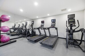A gym with multiple treadmills, exercise balls, and a mirrored wall. - Holiday Inn Express & Suites RALEIGH WEST - LENOVO CENTER by IHG (Meredith)