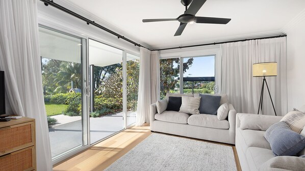 A modern living room with a sofa, a TV, and a floor lamp.