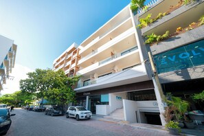 Un immeuble à plusieurs étages doté de balcons, d’une salle de sport et d’un espace de stationnement.