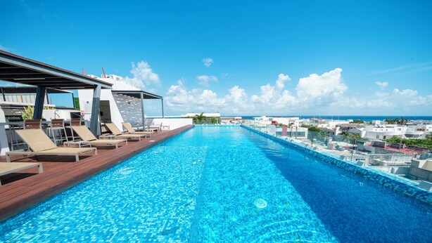 Une piscine avec des chaises longues et vue sur l’océan.