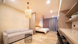 Un salon moderne comprenant un canapé, une petite table ronde, un lit et un coin repas avec des chaises.